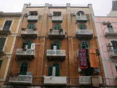 Foto 16. Mentre su via Abate Gimma troviamo un palazzo di ben quattro piani con il prospetto scolorito. Ma qui le persiane ad arco, i decori stilizzati e le originarie balaustre bianche donano all�edificio un aspetto �esotico� ed orientaleggiante, accentuato dalle coloratissime e sgargianti lenzuola stese, segno della grande presenza di immigrati in questo rione 